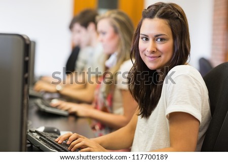 Woman sitting at the computer while smiling in college computer room
