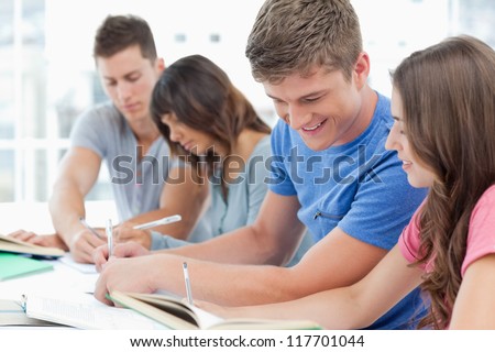 A side view shot of two couples helping each other with homework