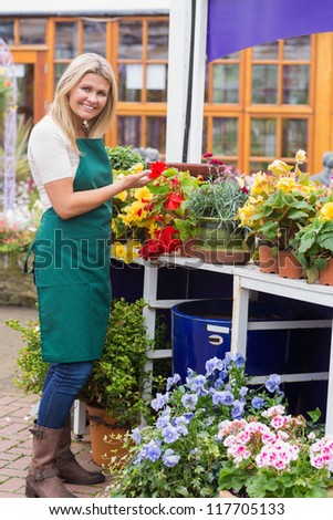 Woman working in garden center handling the flowers