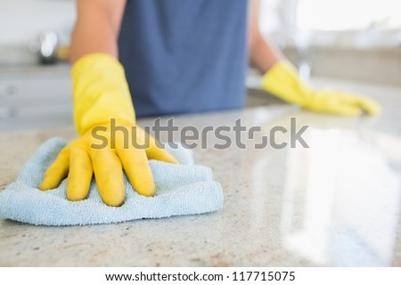 Woman cleaning the counter  in the kitchen
