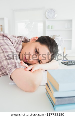 Woman leaning on table while looking away in a living room