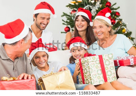 Happy family at christmas swapping gifts on the couch