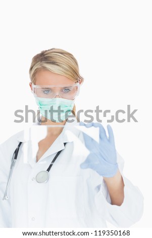 Female doctor wearing surgical gear looking at glass pane