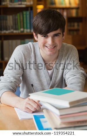Man sitting at library desk at the college library smiling