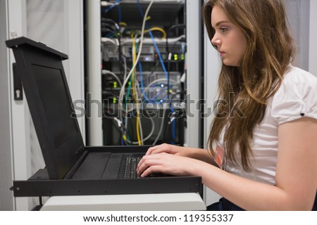 Woman running diagnostics on servers in data center