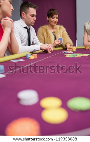 Woman placing bet at poker game in casino