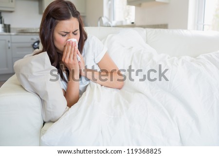 Brunette woman feeling ill on sofa