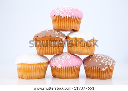 Pyramid of muffins with icing sugar against a blue background