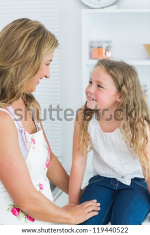 Smiling mother and daughter looking into each other\'s eyes