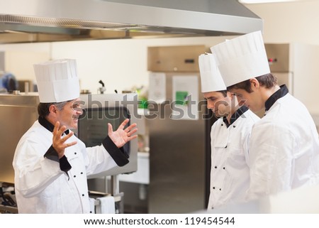 Head chef scolding employees in the kitchen