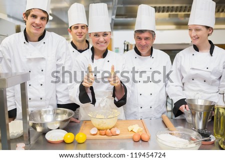 Culinary class with pastry teacher giving thumbs up in kitchen