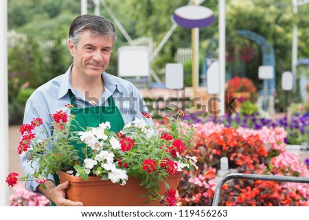 Man holding pot with flowers in garden center