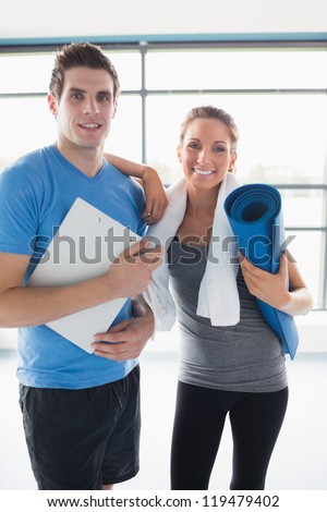 Trainer with a happy client in gym