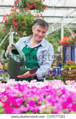 Man watering plants in garden center