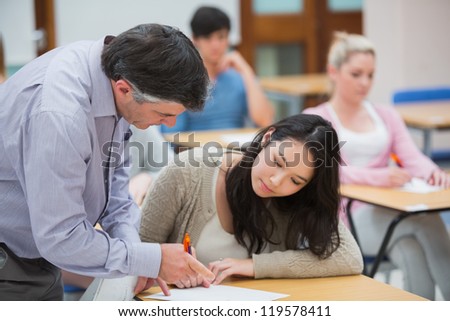 Teacher explaining something to the student in classroom