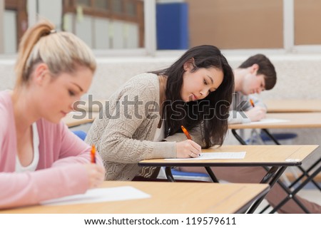 Students taking an exam in exam hall in college