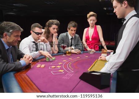 People sitting at table playing poker in a casino