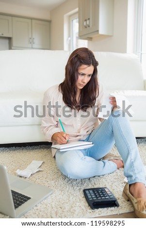 Woman on the carpet calculating and reading the bill