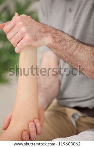 Ankle and elbow of a patient being manipulated in a medical room