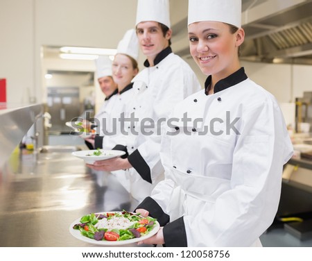 Happy Chef\'s showing their salads in the kitchen