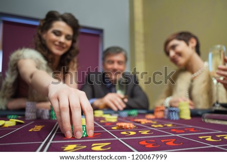 Woman is placing a bet in roulette in casino