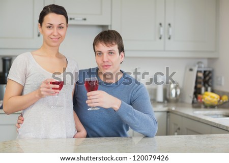 Two people enjoying the togetherness while drinking wine in the kitchen