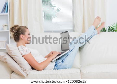 Woman sitting on the sofa and relaxing while using the laptop