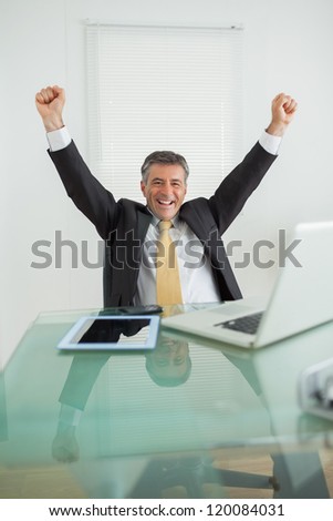 Business man enjoying his success and cheering in his office
