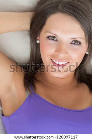 Happy woman lying on sofa in the living room