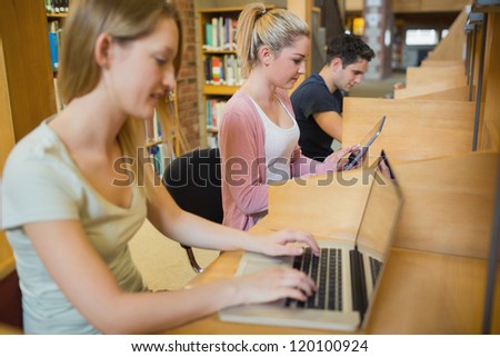 Students studying in a row at study desks in college library