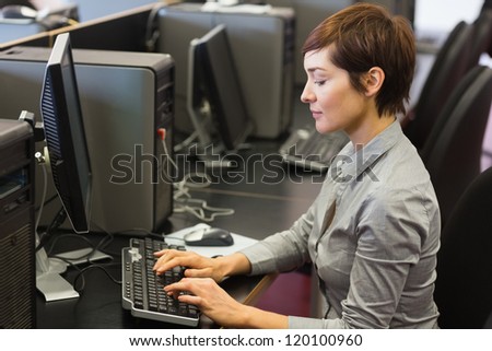 Woman sitting at the computer at the computer room typing