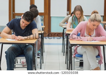 Students taking exams in exam hall in college
