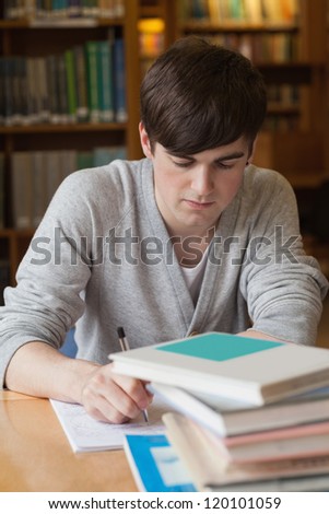 Man sitting at table at the library writing