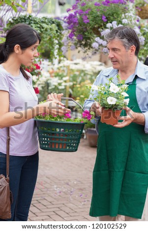 Woman talking to garden center employee holding a basket