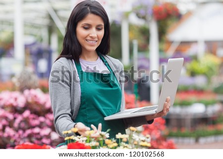 Woman checking stocks with a laptop in garden center