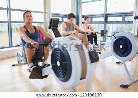 People working out on row machines in fitness studio