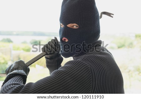 Robber with a crow bar in a home