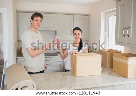 Two young people standing in the kitchen and while celebrating the relocation