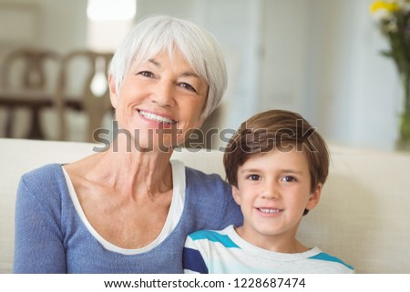 Portrait of grandmother sitting with her grandson on sofa at home