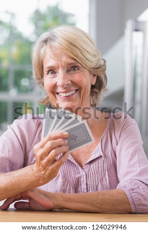 Smiling woman playing cards in the kitchen