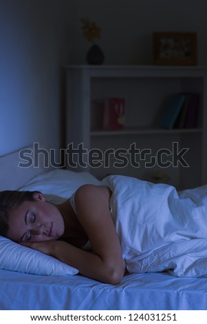 Blonde woman sleeping at night in the bedroom