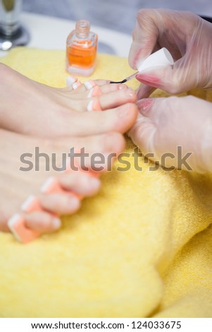 Close-up of woman applying nail varnish to toe nails at spa center