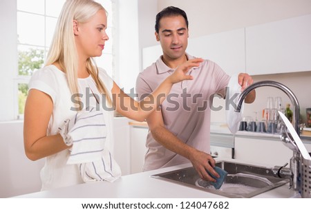 Couple washing dishes together in the kitchen