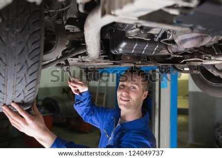 Portrait of young man repairing car in garage