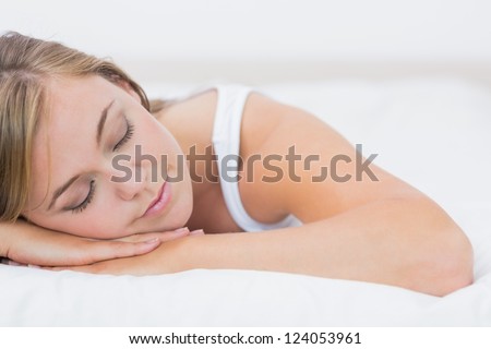 Calm woman napping on the bed in the white bedroom