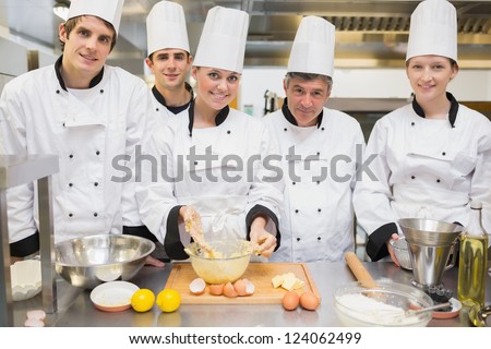 Smiling culinary class with pastry teacher in kitchen