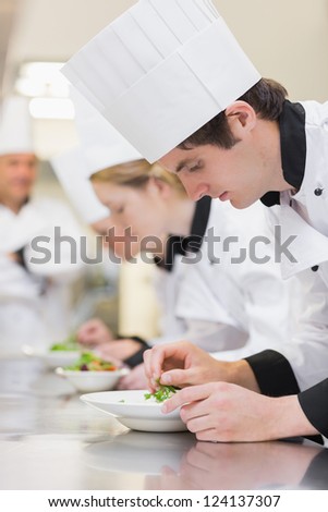 Culinary class making salads with teacher watching over