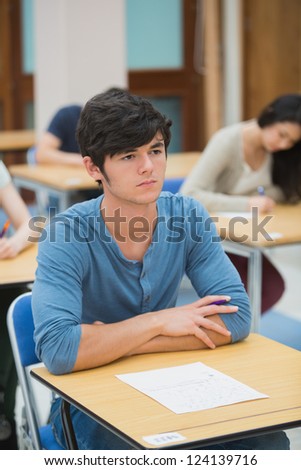 Student looking up during exam in exam hall