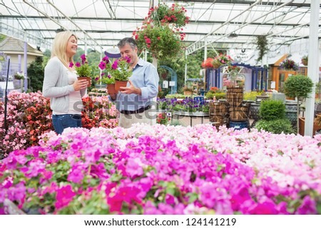 Couple choosing flowers in the garden centre while talking