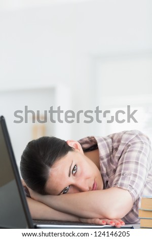 Woman leaning on table with laptop in living room